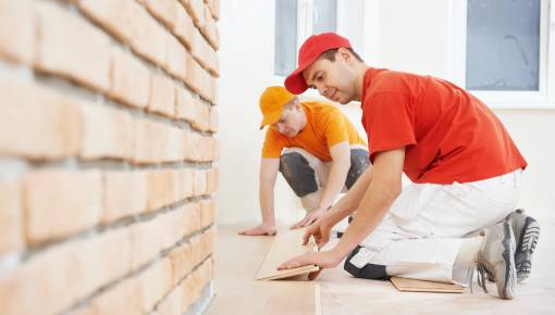 two professionals installing wood floors
